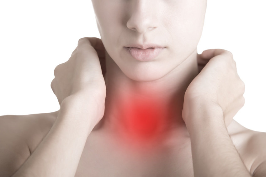 Woman with a sore throat holding her neck