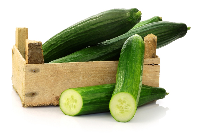 fresh cucumbers and a cut one in wooden box