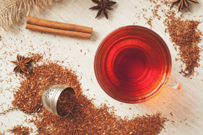 Rooibos traditional organic dieting drink. Healthy superfood beverage rooibos african tea with spices on vintage wooden background