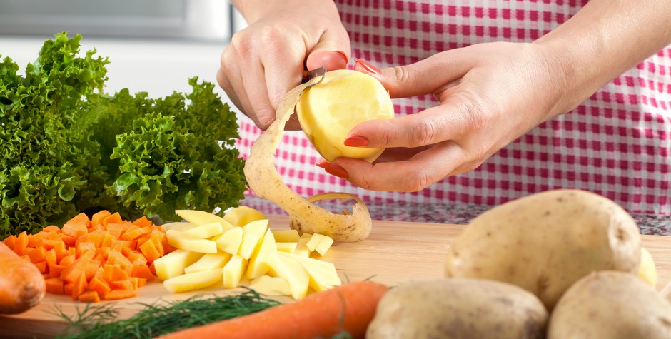 Woman is peeling potato and preparing dinner for family