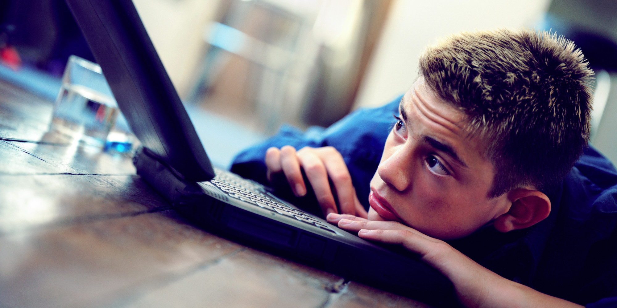 Boy (12-14) resting on laptop
